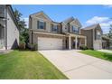 Two-story house with brick and siding, large windows, and a two-car garage. Concrete driveway at 435 Auburn Crossing Dr, Auburn, GA 30011