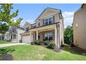 Two-story house with brick and siding, large windows, and a two-car garage. Landscaped yard at 435 Auburn Crossing Dr, Auburn, GA 30011