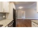 Kitchen with granite countertops, stainless steel appliances, and hardwood floors, flowing into living space at 3080 Santa Monica Dr, Decatur, GA 30032