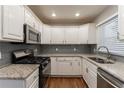 Modern kitchen with white cabinets, granite countertops, stainless steel appliances, and tile backsplash at 3080 Santa Monica Dr, Decatur, GA 30032