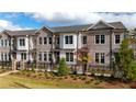 Brick townhome with black fence and landscaping at 620 Goldsmith Ct # 107, Johns Creek, GA 30022