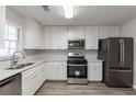 Renovated kitchen with white cabinets, stainless steel appliances, and quartz countertops at 5725 Twain Dr, Ellenwood, GA 30294