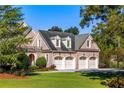 Three-car garage with brick exterior and manicured lawn at 4000 Heatherwood Way, Roswell, GA 30075