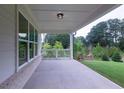 Covered patio with gray brick foundation and exterior featuring a great view of the surrounding backyard and greenery at 5320 Memento Trace, Cumming, GA 30040