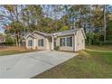 Front view of a charming house with a concrete driveway and grassy yard at 7133 Pineview Sw Dr, Covington, GA 30014