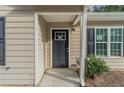 Front door entry with a dark gray door and white trim at 7133 Pineview Sw Dr, Covington, GA 30014