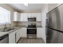 Modern kitchen featuring stainless steel appliances, granite countertops, and white cabinets at 128 Prity Ct, Mcdonough, GA 30253