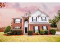 Two-story brick home with gray siding, landscaped lawn, and attached garage at 4126 Mcbride Dr, Powder Springs, GA 30127