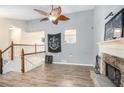 Inviting living room featuring wood floors, vaulted ceiling with fan, stone fireplace and staircase at 118 Gilberts Way, Temple, GA 30179