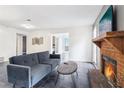 Cozy living room features a brick fireplace, gray sofa, and open doorway to the home at 1525 Terrell Mill Se Pl # A, Marietta, GA 30067