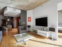 Open living area with hardwood floors, large TV, and comfortable seating at 943 Peachtree Ne St # 902, Atlanta, GA 30309