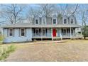 Two-story house with a covered porch and a red door at 3898 Buckland Dr, Lilburn, GA 30047