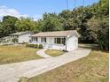 Charming white painted home with a long driveway and a lush, green, tree-filled yard at 3453 Eisenhower E Cir, Atlanta, GA 30354