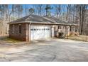 Spacious brick home featuring an attached garage and concrete driveway in a wooded setting at 490 Dorsey Road Rd, Hampton, GA 30228