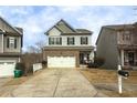 Two-story home with a white garage door, welcoming porch and landscaping at 135 Cessna Dr, Canton, GA 30114