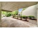 Covered carport with concrete flooring, lush greenery, and a glimpse of a neighboring property at 104 Woodhaven Way, Alpharetta, GA 30009