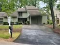 Inviting home with covered carport, lush landscaping, and a 'For Sale' sign on a well-maintained lawn at 104 Woodhaven Way, Alpharetta, GA 30009