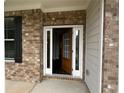 Inviting front entry with brick facade and decorative wood door with glass panels, flooding the foyer with natural light at 2180 Highridge Point Dr, Lithia Springs, GA 30122