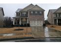Two-story brick home with a three-car garage and landscaped yard at 2368 Misty Ivy Ct, Buford, GA 30519