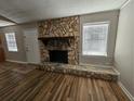 Cozy living room boasts a stone fireplace, hardwood floors, and plenty of natural light at 432 Independence Dr, Jonesboro, GA 30238