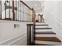 Elegant staircase featuring dark wood steps, decorative iron spindles, and a bright, white wainscoted wall at 3261 Ferncliff Ln, Atlanta, GA 30324