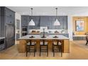 Gourmet kitchen features gray cabinetry, quartz countertops, and breakfast bar at 6430 Pond View Dr, Cumming, GA 30028