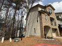 Side view of a brick townhome with vinyl siding and attached one car garage at 2912 Ashlyn Pointe Dr, Atlanta, GA 30340