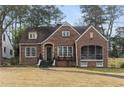 Charming brick home featuring manicured front yard and an inviting entrance at 1703 Noble Ne Dr, Atlanta, GA 30306