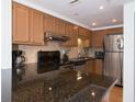 Modern kitchen, granite counters, stainless steel appliances, and wood cabinets at 199 14Th Ne St # 1209, Atlanta, GA 30309