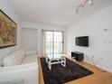Living room features hardwood floors, white couch, and balcony access at 199 14Th Ne St # 1209, Atlanta, GA 30309