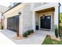 Inviting front entrance with black double doors, gray brick, and landscape at 771 Arrendale Dr, Marietta, GA 30064