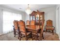 Spacious dining room featuring a wooden table, ornate chairs, a decorative china cabinet, and soft natural lighting at 661 Towering Pine Se Trl, Lawrenceville, GA 30045