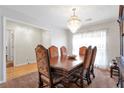 Elegant dining room with a chandelier, a large wooden table with upholstered chairs, and natural light at 661 Towering Pine Se Trl, Lawrenceville, GA 30045