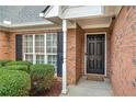 Close-up of a brick home's entrance, showcasing a classic black front door and neat landscaping at 661 Towering Pine Se Trl, Lawrenceville, GA 30045