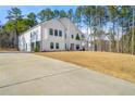 White modern farmhouse with attached garage and expansive lawn at 130 Wesley Place, Fayetteville, GA 30214