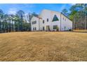 Contemporary farmhouse exterior with expansive lawn and wooded backdrop at 130 Wesley Pl, Fayetteville, GA 30214