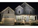 Charming two-story home with inviting front porch, garage, and manicured landscaping at night at 1553 Brunswick St, Lithia Springs, GA 30122