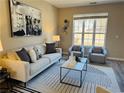 Bright living room with a comfortable sofa, accent chairs, a stylish rug, and a large window at 355 Holland Springs Way, Powder Springs, GA 30127