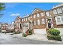 Attractive townhome showcasing brick facade, an attached garage, and tidy green shrubs at 5104 Leeshire Se Trl # 64, Atlanta, GA 30339