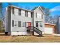 Charming two-story home with gray siding, black shutters, red front door, and attached two car garage at 4390 Allgood Pl, Stone Mountain, GA 30083