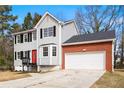 Charming two-story home with gray siding, black shutters, red front door, and attached two car garage at 4390 Allgood Pl, Stone Mountain, GA 30083