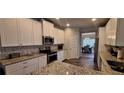 Kitchen with granite countertops, white cabinets, and stainless steel appliances at 6268 Odum Cir, Covington, GA 30014