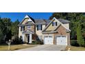 Two story house with stone and shingle accents, two car garage, and landscaped yard at 2005 Creek Pointe Way, Villa Rica, GA 30180