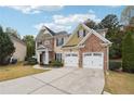 Two story house with stone and shingle accents, two car garage, and landscaped yard at 2005 Creek Pointe Way, Villa Rica, GA 30180