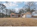 Single-story house with a yard, trees, and a driveway at 2426 Windridge Dr, Conyers, GA 30013