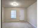 Bright bedroom featuring neutral carpet, a window with blinds, and a white door at 2192 Landing Walk Dr, Duluth, GA 30097