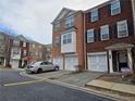 Brick townhome featuring a one car garage, symmetrical windows and professionally maintained landscaping at 2192 Landing Walk Dr, Duluth, GA 30097