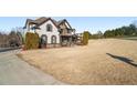 Two-story house with stone and shingle accents, and a wrap-around porch at 6610 Wesley Trail Holw, Cumming, GA 30028