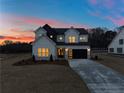 Two-story farmhouse at dusk, showcasing the exterior lights and landscaping at 4265 Haynes Cir, Snellville, GA 30039