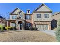 Two-story home with brick and stone accents, a two-car garage, and a well-maintained front lawn in a suburban setting at 4610 Point Rock Dr, Buford, GA 30519